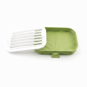 White ripple tray lifted out and leaning against the edge of the matcha green soap dish