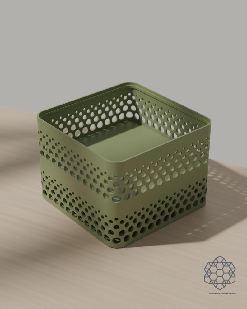 May include: A square olive green storage bin featuring a perforated pattern of circular cutouts that vary in size across the sides. The container has a solid flat base and an open top with a reinforced rim, constructed from a smooth, matte material.