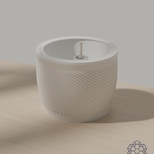 The Aquapot self watering planter in alabaster off-white, its spiral ridged wall lit from the side, with the soil insert and float cap in place on a wooden table. Images include 3D-rendered visualizations of the exact print files.