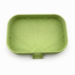 Inside of the empty matcha green dish showing the engraved swirl floor that guides drips to the spout
