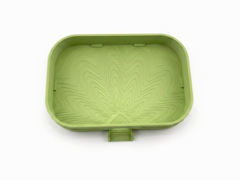 Inside of the empty matcha green dish showing the engraved swirl floor that guides drips to the spout