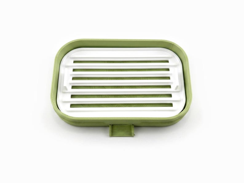 Top view of the matcha green soap dish with its white ripple drying tray inside, on a white background