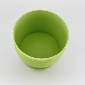 The matcha green vessel on its own with the insert removed, angled to show the smooth empty water reservoir inside and the spiral ridged outer wall.