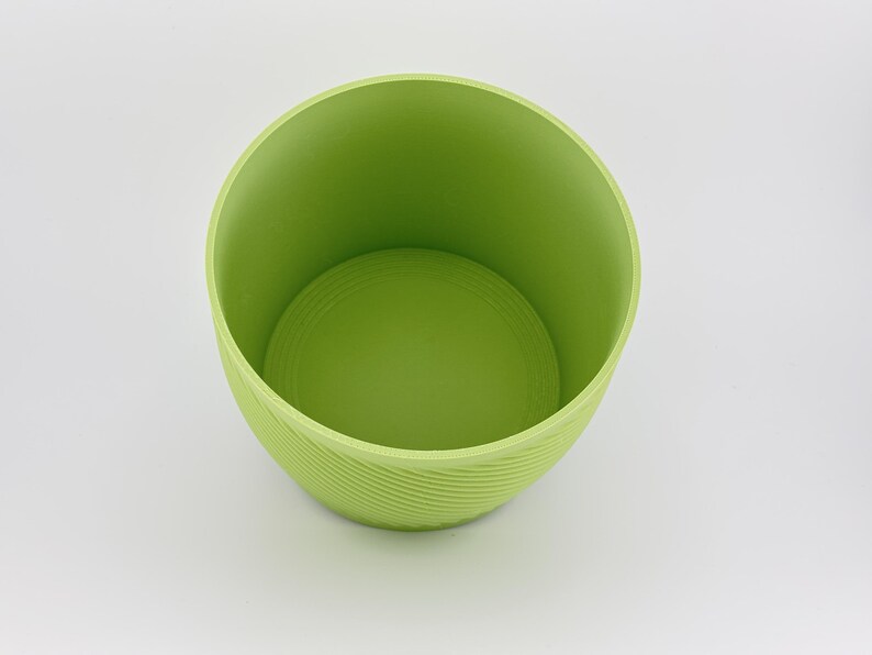 The matcha green vessel on its own with the insert removed, angled to show the smooth empty water reservoir inside and the spiral ridged outer wall.