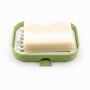 Cream bar of soap resting on the white ripple tray inside the matcha green soap dish