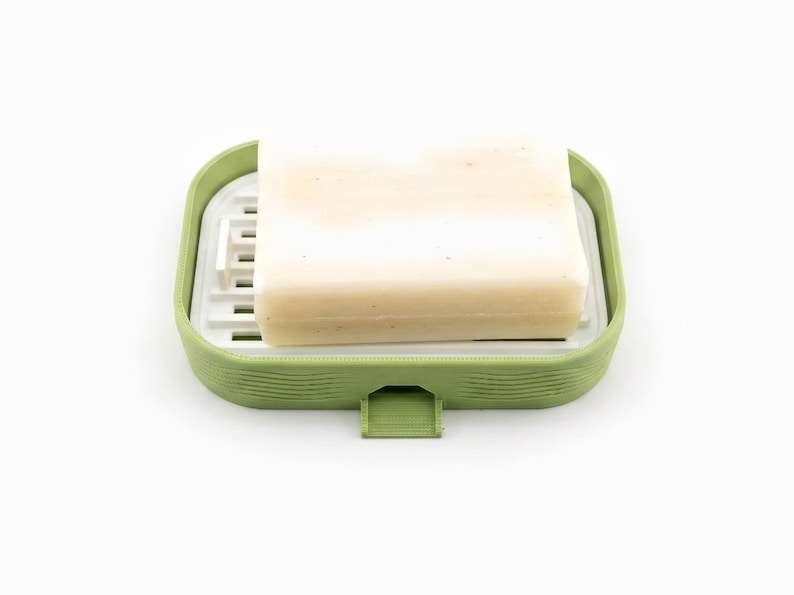 Cream bar of soap resting on the white ripple tray inside the matcha green soap dish