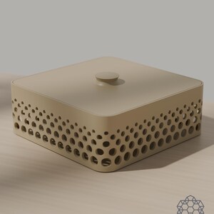 May include: A square, beige storage box with a flat lid and a small central knob. The sides feature a decorative pattern of circular cutouts that vary in size, creating a gradient effect. The box has rounded corners and a smooth, matte finish.