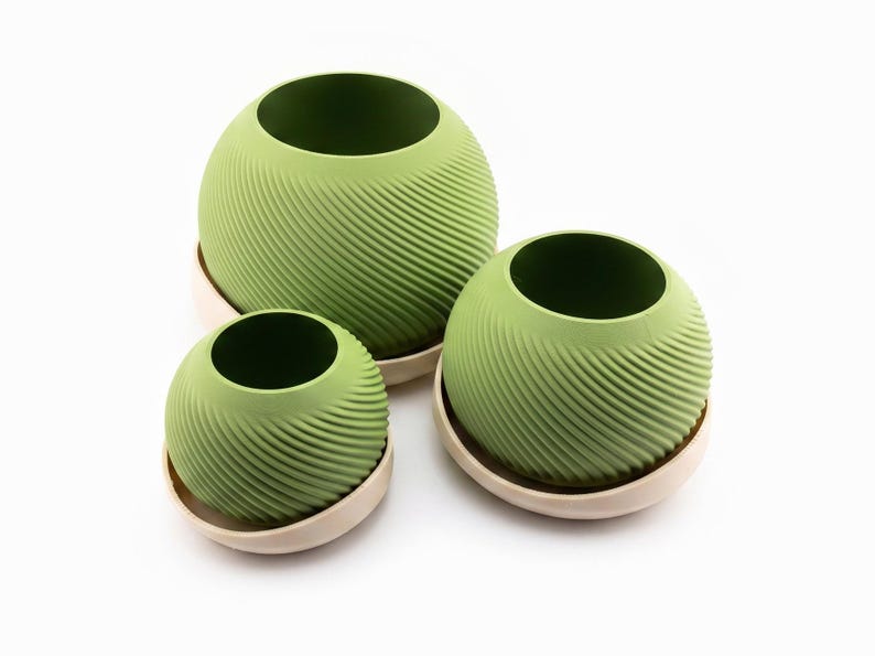 Looking down at three sizes of matcha spiral planters grouped in their cream saucers