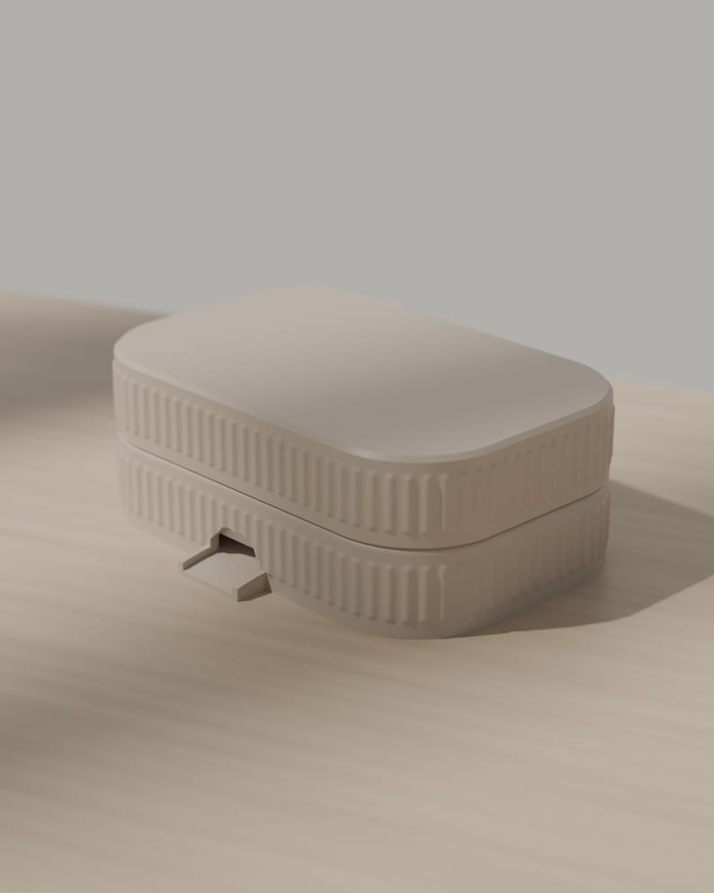 May include: A rectangular, light beige storage box with rounded corners and a ribbed, vertical texture along the sides. The container features a flat lid and a small, protruding latch mechanism on the front edge, constructed from a solid material.