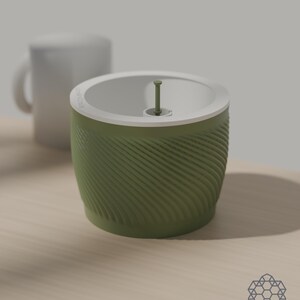 Size comparison: the matcha green Aquapot self watering planter, 127 mm across and 100 mm tall, stands beside a plain white mug on a wooden table. Images include 3D-rendered visualizations of the exact print files.