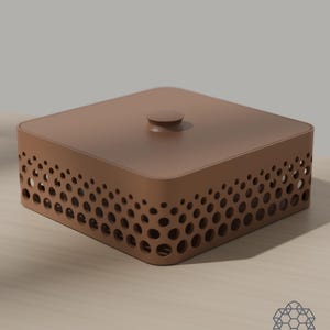 May include: A square, matte brown storage box with a flat lid and a small central knob. The sides feature a perforated pattern of circular cutouts that vary in size, creating a gradient effect. A small geometric logo is visible in the corner.