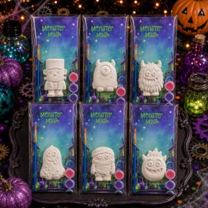 Puede incluir: Seis kits de manualidades Monster Mash en envases de plástico transparente. Cada kit contiene una figura de monstruo blanca sin pintar, un pincel pequeño y tres botes de pintura pequeños. Las tarjetas traseras tienen un diseño de galaxia.