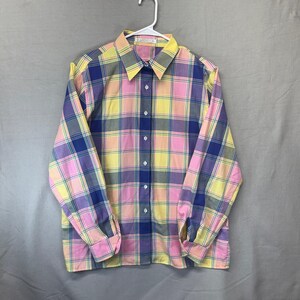 May include: A long-sleeve button-down shirt featuring a multi-colored plaid pattern in shades of yellow, pink, blue, and purple. The shirt has a classic collar, a front button placket with white buttons, and buttoned cuffs on the sleeves.