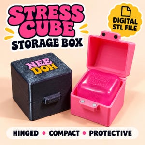 May include: A black, glittery, square storage box with the text "NEE DOH" on the lid, next to an open, bright pink, hinged storage box containing a pink square object with "NEE DOH" embossed on it. The text "STRESS CUBE STORAGE BOX" is visible.