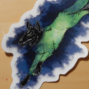 May include: A black and green wolf silhouette with a galaxy pattern, leaping through a dark blue and green nebula. The wolf's eyes are glowing white.