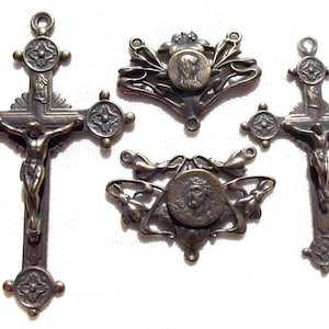 Könnte beinhalten: Vier antike religiöse Anhänger aus Bronze, darunter zwei Kruzifixe mit einer Jesus Christus-Figur und zwei verzierte Medaillons mit einem zentralen Bild von Jesus Christus.