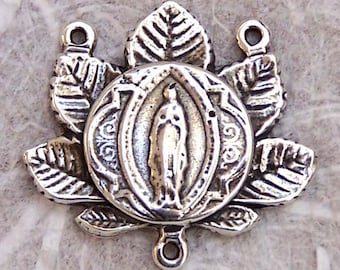 May include: Silver-toned metal rosary charm featuring a depiction of the Virgin Mary within a circular frame surrounded by leaves.