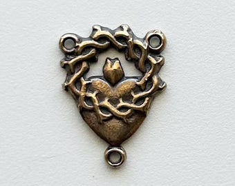 Centro de mesa con corona de espinas y medalla milagrosa del Sagrado Corazón.