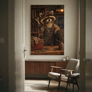 Op de afbeelding: Een wandkunstprint met een wasbeer die een bruine veiligheidsbril en een spijkerbroek draagt in een werkplaats. De wasbeer houdt een zilveren moersleutel vast, met een rode gereedschapskist, een band en diverse gereedschappen op een werkbank.