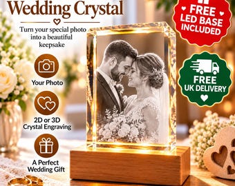 Puede incluir: Un bloque de cristal rectangular con una imagen grabada con láser de una pareja con ropa de boda, colocado sobre una base de madera rectangular. El cristal está iluminado desde abajo, resaltando el retrato detallado de ambos.