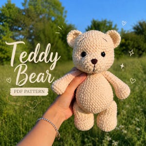 May include: A light beige crochet teddy bear with dark brown eyes and a dark brown stitched nose. The text on the image reads Teddy Bear PDF PATTERN. The bear has rounded ears, a round body, and simple limbs, crafted with a textured yarn finish.