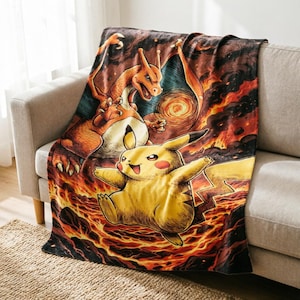 Può includere: Una coperta rettangolare con una vivace stampa grafica che raffigura il personaggio giallo Pikachu in primo piano e il personaggio arancione simile a un drago Charizard sullo sfondo, immersi in uno scenario di lava e fiamme vorticose.