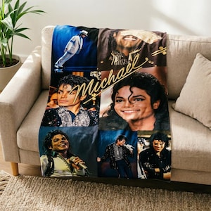 Puede incluir: Una manta suave que presenta un collage de varias fotografías de Michael Jackson con diferentes atuendos y poses de actuación, con el nombre Michael escrito en una letra cursiva dorada en el centro del diseño de la tela.