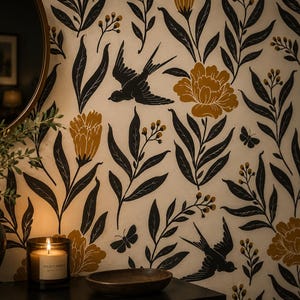 May include: Wallpaper featuring a repeating pattern of black swallows, small butterflies, and mustard yellow flowers with dark green leaves on a cream background. A dark vase, a lit candle in a glass jar, and a small bowl are positioned in front.