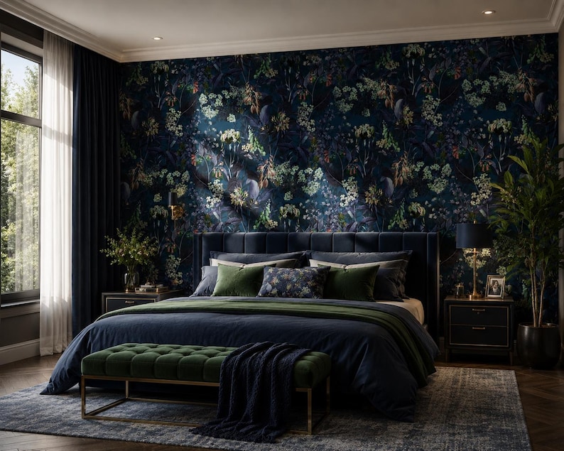 May include: A bedroom featuring dark blue floral wallpaper, a navy blue upholstered bed with green and patterned pillows, a dark blue duvet, a green velvet bench with a gold frame, two dark nightstands, and a tall green potted plant.