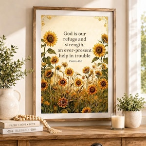 May include: A framed wall art print featuring a field of yellow sunflowers and the text: God is our refuge and strength, an ever-present help in trouble. Psalm 46:1. The artwork is displayed in a light brown wooden frame with a cream-colored background.