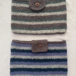 May include: Two rectangular pouches made of textured, fuzzy yarn featuring horizontal stripes. The top pouch has grey, teal, and white stripes with a central flap and a small brown button. The bottom pouch has blue, navy, and grey stripes with a matching flap and button.