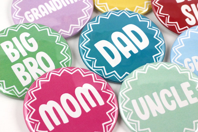 May include: A set of nine colorful round buttons with white text. The buttons feature the words "Big Bro", "Mom", "Dad", "Grandma", "Grandpa", "Uncle", "Sister", "Brother", and "Auntie".