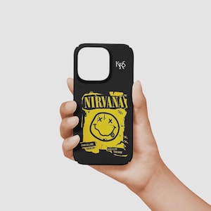 Puede incluir: Una funda de smartphone negra con un estampado gráfico amarillo del logotipo de la banda Nirvana, una cara sonriente, el texto NIRVANA, 1987, COME AS U ARE, THEATER, SMELLS LIKE TEEN SPIRIT y las letras KRS en blanco en la esquina superior derecha.
