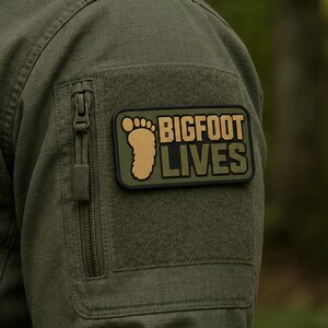 Toppa in PVC Bigfoot Lives / Emblema tattico di Sasquatch e criptozoologia (con velcro)