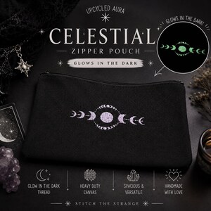 Op de afbeelding: Een zwarte etui met rits en een geborduurd maanfasenontwerp. De tekst luidt "UPCYCLED AURA CELESTIAL ZIPPER POUCH GLOWS IN THE DARK". Een cirkelvormig inzetstuk toont het borduurwerk dat in het donker oplicht. Overige tekst: "GLOW IN THE DARK THREAD", "HEAVY DUTY CANVAS", "SPACIOUS & VERSATILE", "HANDMADE WITH LOVE" en "STITCH THE STRANGE".