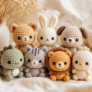 Puede incluir: Una colección de siete pequeños animales de peluche tejidos a ganchillo que incluye un oso marrón claro, un conejo blanco, un perro beige, un dinosaurio verde, un gato gris a rayas, un león dorado con melena y un pequeño pájaro blanco, todos con ojos negros.