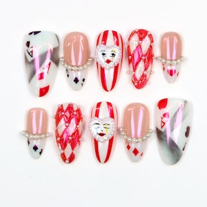 Unghie finte con faccia da clown stravagante, unghie finte 3D rosse e bianche da carnevale, nail art personalizzata con gioco di carte da poker, unghie con maschera da clown, unghie a mandorla da carnevale