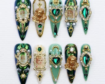 May include: Ten green and gold nail art charms featuring a variety of designs, including hearts, angels, and religious imagery. The charms are designed to be applied to fingernails.