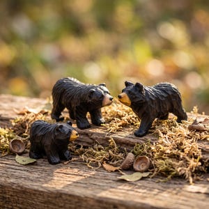 Könnte beinhalten: Drei handgeschnitzte Bärenfiguren aus Holz mit dunkelbraun gebeizten Körpern und helleren, beige bemalten Schnauzen. Die Bären sind in stehender Position dargestellt, mit sichtbarer Holzmaserung und geschnitzten Fellstrukturen.
