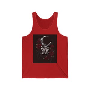 May include: A red tank top featuring a central black square graphic. The graphic displays a white crescent moon, dark red roses, and the white text "MY HALO CLOCKS OUT AT MIDNIGHT" centered below the moon. The tank top has a scoop neckline.