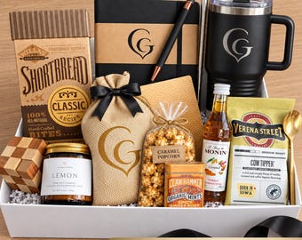 May include: A gift set containing a box of Willa's Shortbread, a black notebook with a pen, a black insulated tumbler with a logo, a burlap bag, a bag of caramel popcorn, a jar of lemon candle, a bottle of Monin syrup, mints, and coffee.