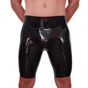 Op de afbeelding: Zwarte latex shorts met een hoogglanzende afwerking. Deze nauwsluitende shorts hebben een glad, naadloos uiterlijk en reiken tot halverwege de dij, wat zorgt voor een strak, reflecterend oppervlak dat de lichaamsvorm volgt.