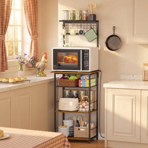 May include: A tall, multi-tiered kitchen storage rack with a black metal frame and brown wooden shelves. It features a top grid panel with hooks for hanging mugs and utensils, a dedicated microwave shelf, and lower levels for storing food and appliances.