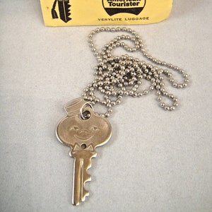 Leuke vintage jaren 60 American Tourister-bagage lachende piccolo mascotte koffer sleutelketting