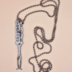 Peut inclure: Un collier en chaîne argentée avec un pendentif en argent qui dit "COOMES THE SAFE WAY".