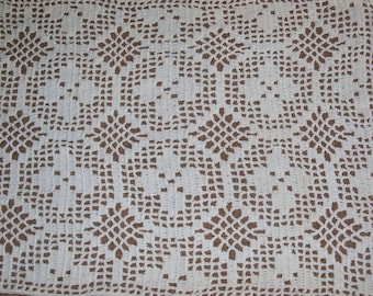 May include: White crocheted doily with a delicate floral pattern. The doily is made of fine thread and has a square shape.