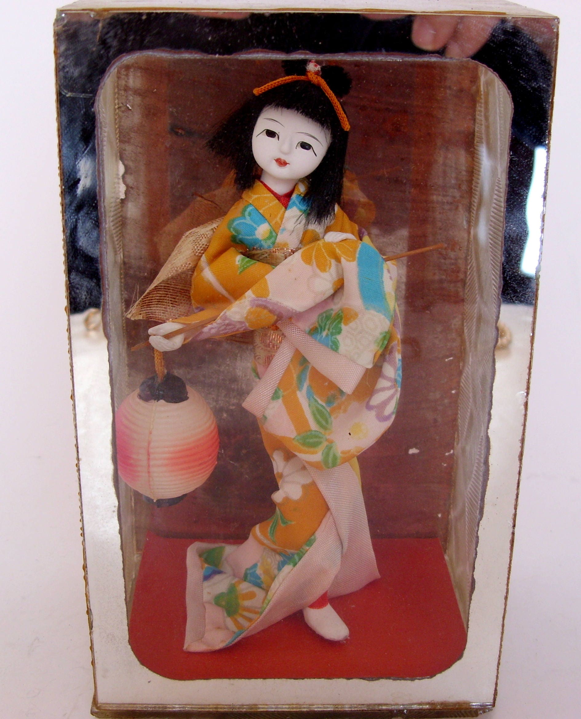 chinese doll in glass case