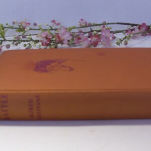 May include: An orange hardback book titled "Bob, Son of Battle" by Alfred Ollivant. The book has a pink illustration on the front cover.