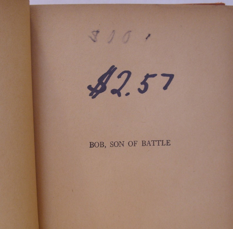 May include: A close-up of a book's title page with the text "BOB, SON OF BATTLE" and a handwritten price tag of &pound;2.57.