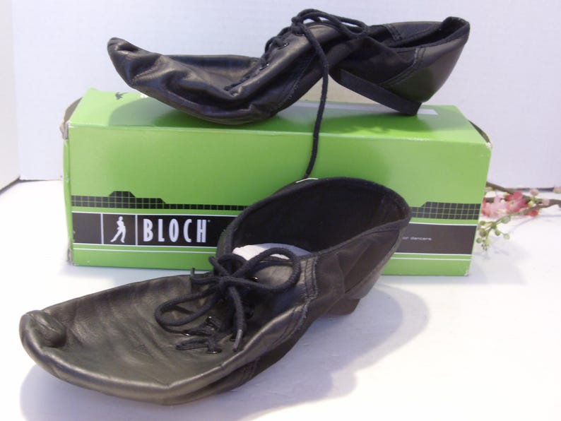 Puede incluir: Zapatos de baile de cuero negro con cordones, colocados sobre una caja verde. La caja presenta la marca "BLOCH". Estos zapatos de baile tienen una suela flexible. Los cordones est&aacute;n atados. Los zapatos son nuevos.